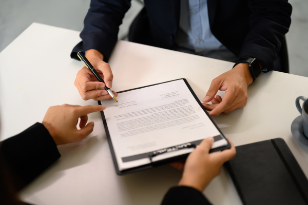 Agent and a couple sitting at a table reviewing a term life insurance plan to secure financial stability and future protection.
